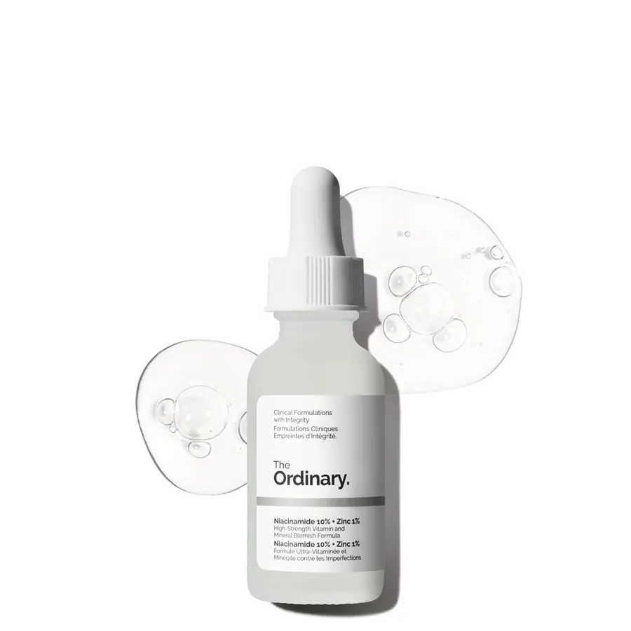 Close-up of The Ordinary Niacinamide serum bottle with a hand applying a few drops to fingertips